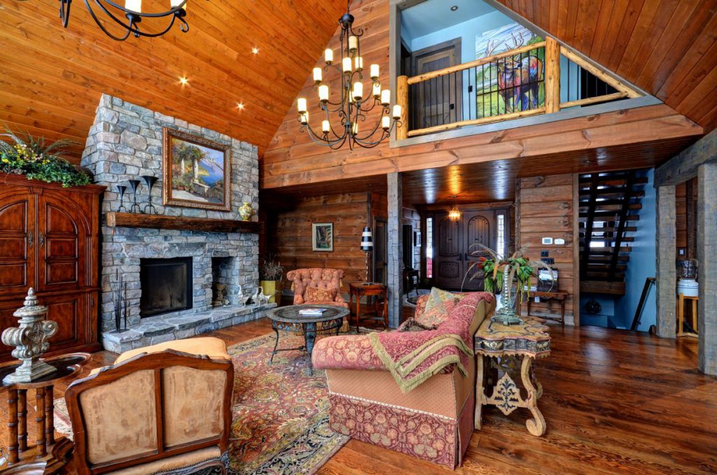 large cabin with a fireplace in haliburton